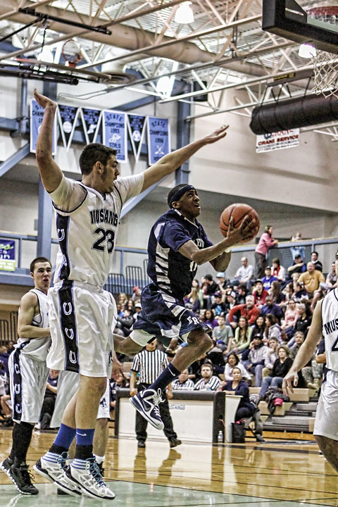 Junior Shaquan Rhoades attempts a layup through traffic