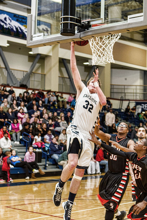 Two West players are dunked on by Senior Kevin Waterman