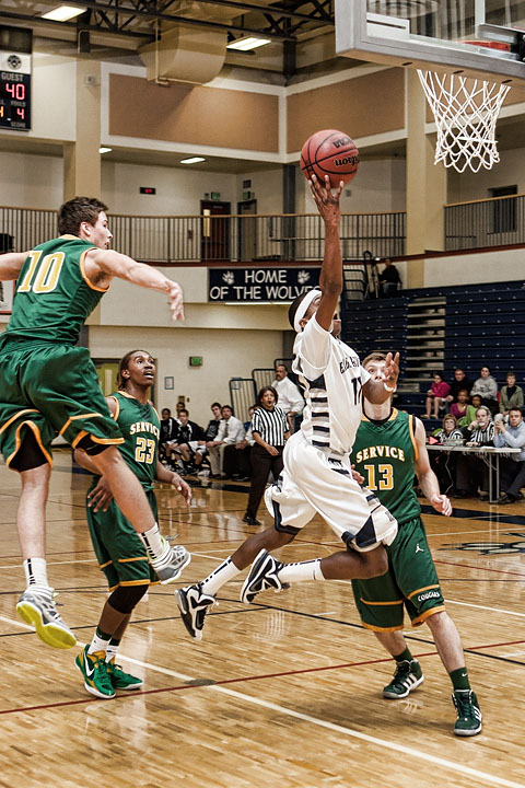 Junior Shaquan Rhoades throws up a shot between the Service defense