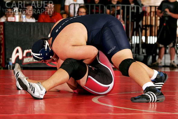 December 12th, 2012: A Mullen wrestler uses his weight to try to keep a Arvada wrestler on the mat in their meet at Arvada Senior High School