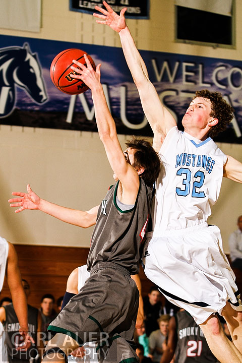 February 27th 2013: Arvada, Colorado - Ralston Valley Mustang junior Jonathon Gillespie elevates to block the shot by Smoky Hill's Connor Mooney in the playoff game at Ralston Valley High School