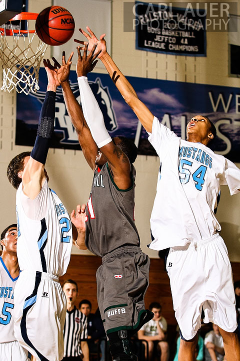 February 27th 2013: Arvada, Colorado - Smoky Hill Buffaloes Jaylen Petty (21) sneaks a shot up past the defense from Ralston Valley Mustangs freshman Dallas Walton (54) and senior Spencer Svejcar (20) in the first round state playoff game at Ralston Valley High School