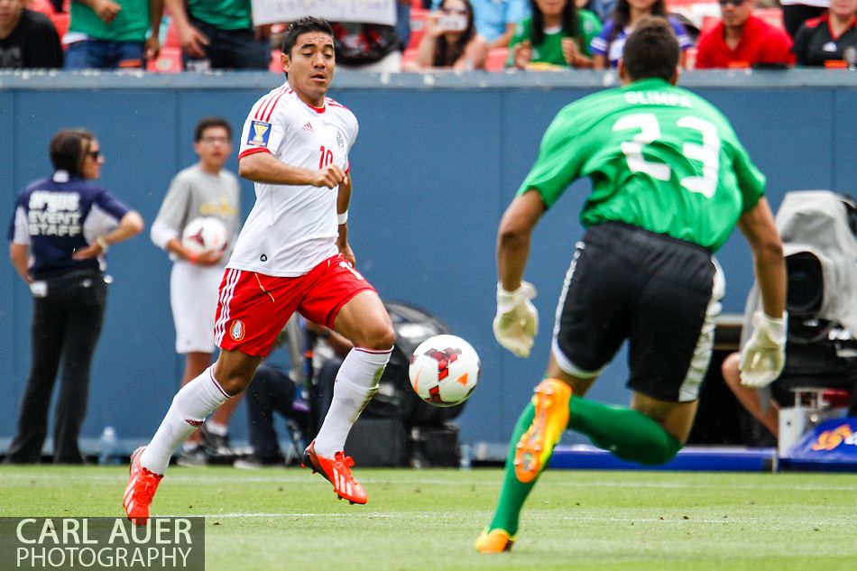 July 14 2013:  Mexico Forward Marco Fabian (10) attacks the charging Martinique Goalie Kevin Olimpa (23) during the first half of the CONCACAF Gold Cup soccer match between Martinique and Mexico at Sports Authority Field in Denver, CO. USA.