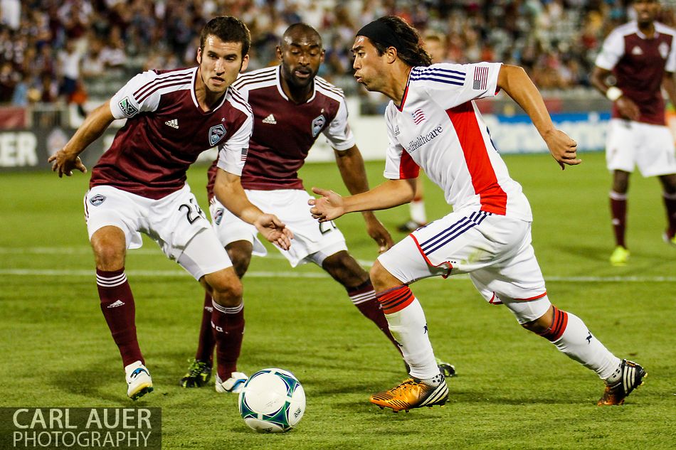 July 17th, 2013 - New England Revolution midfielder Lee Nguyen (24) attempts to run the ball around Colorado Rapids midfielder Nathan Sturgis (24) and defender Marvell Wynne (22) in the second half of the Major League Soccer match between the New England Revolution and the Colorado Rapids at Dick's Sporting Goods Park in Commerce City, CO