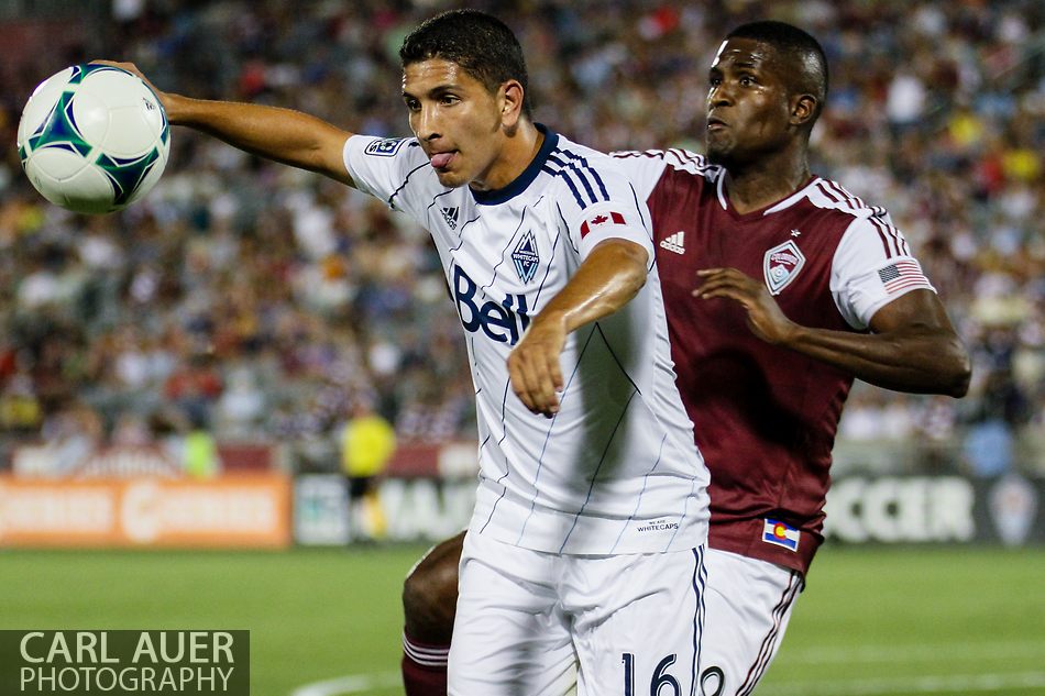 August 17th, 2013 - Vancouver Whitecaps FC defender Johnny Leveron (16) tries to keep the ball away from Colorado Rapids forward Edson Buddle (9) in the second half of action in the Major League Soccer match between the Vancouver Whitecaps FC and the Colorado Rapids at Dick's Sporting Goods Park in Commerce City, CO